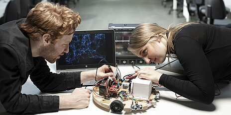 Zwei Studierende arbeiten an einem Prototypen.