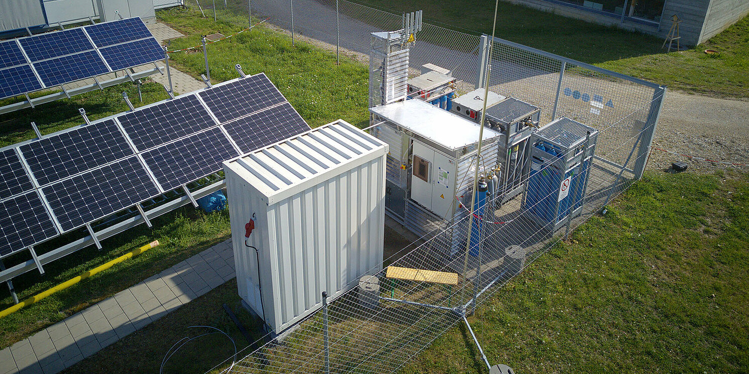 Freifläche mit Photovoltaikmodulen und einer Versuchsanlage zur Methanisierung von Wasserstoff