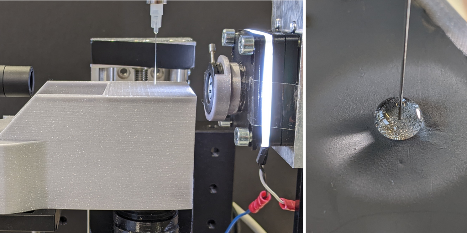 Eine Prüfnadel dringt in eine kugelförmige transparente Materialprobe ein; zu beiden Seiten wird die Vorrichtung ergänzt durch ein Beleuchtungs- und ein Kamerasystem.